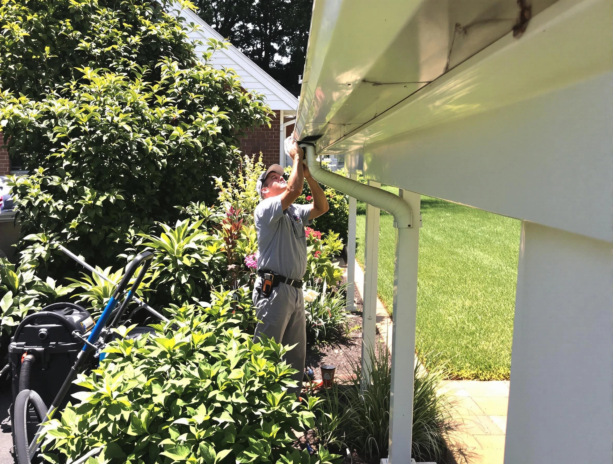 Technician flushing a blockage from a downspout in Maple Heights, OH